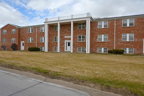 A red brick building with a white trim around the windows and doors.